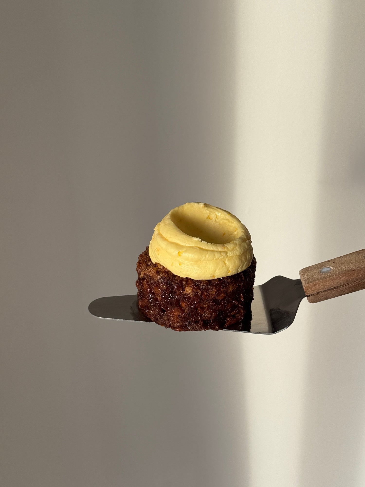 A mini round gluten free Carrot Cake topped with orange flavoured frosting