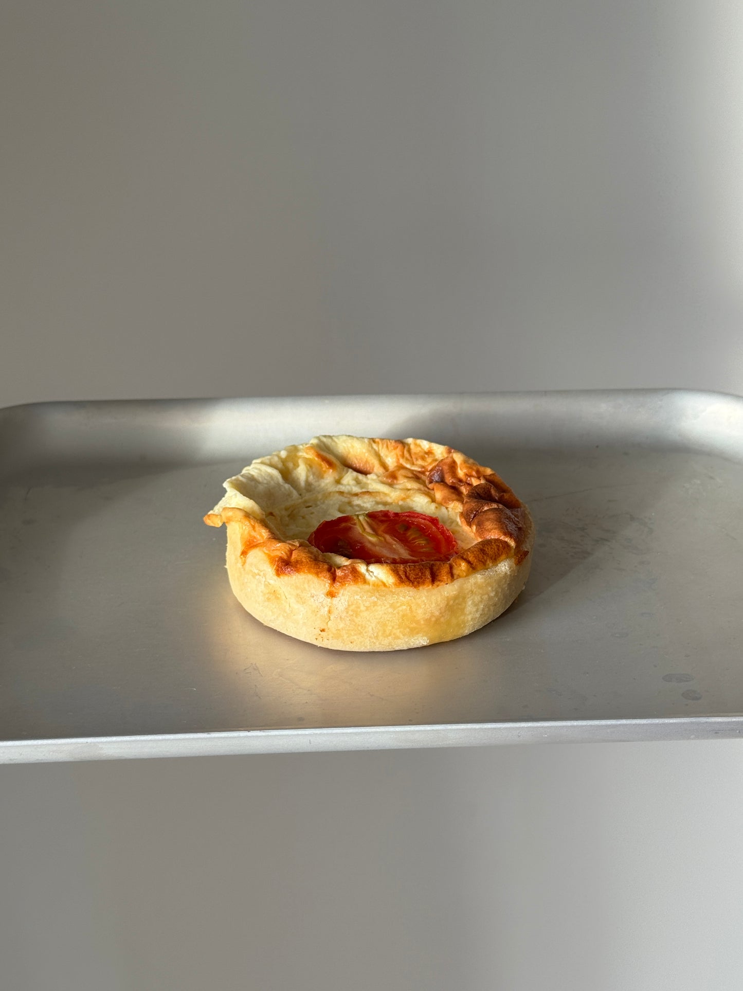A small round gluten free cheese and tomato quiche